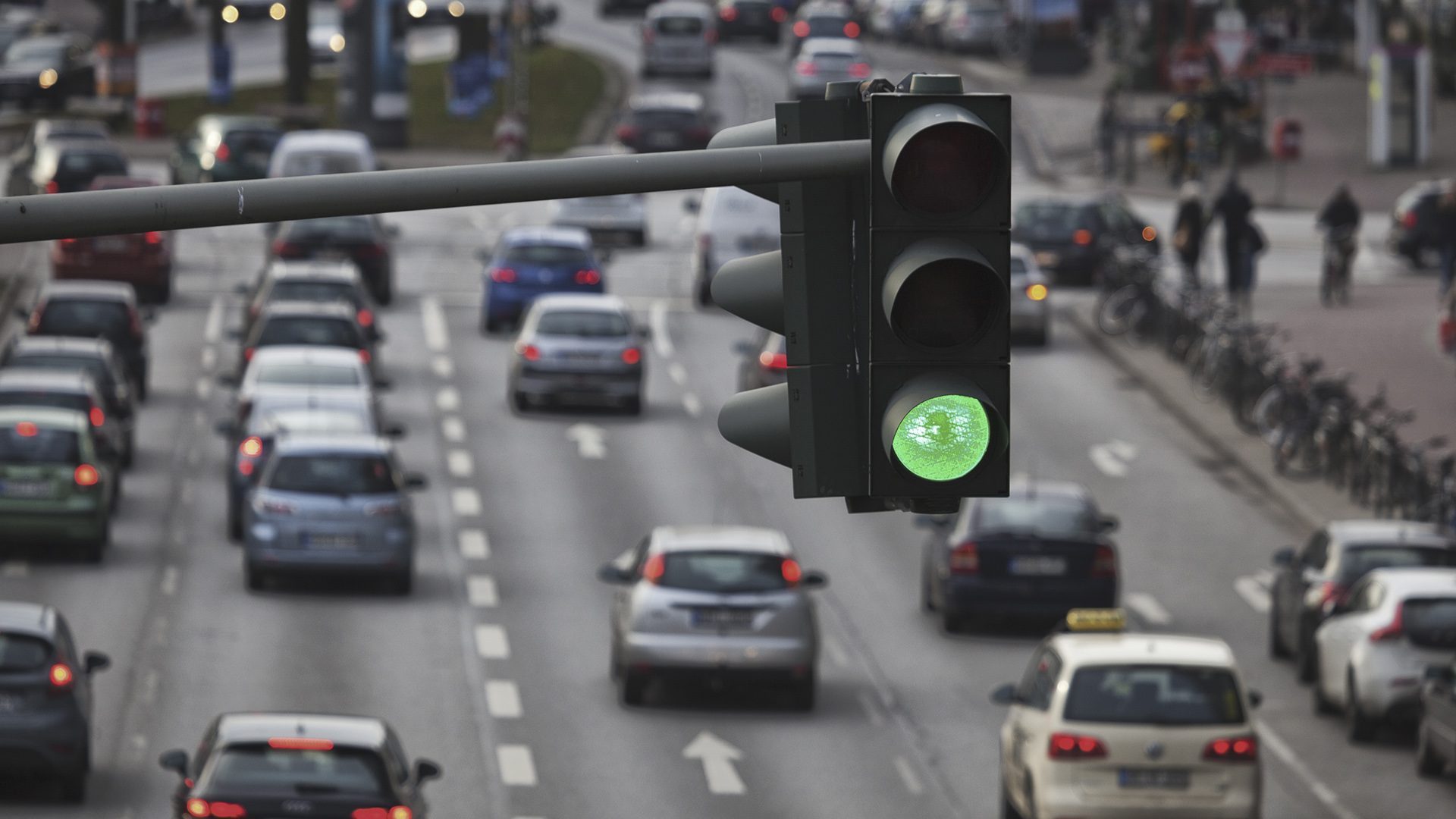 Grønt trafiklys på en trafikkeret vej.