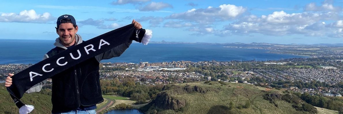 PBK der holder et Accura halstørklæde fremme i en udsigt over Skotland.